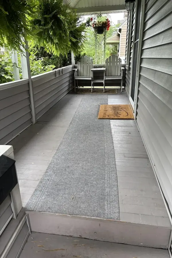 Before: Porch with old flooring and railings.