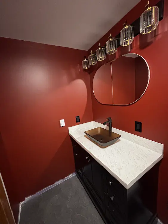 After: Striking red walls, modern vanity, and updated fixtures